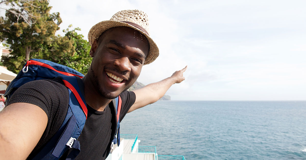 Traveling man points excitedly out towards the ocean