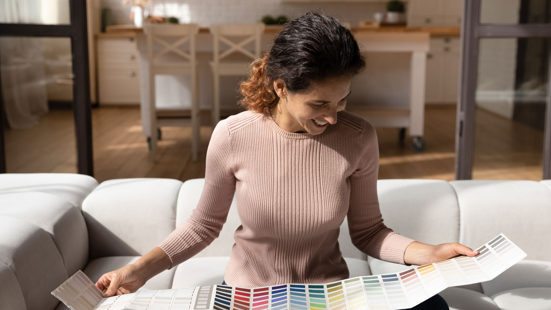 Woman excitedly looking at a book of paint swatches