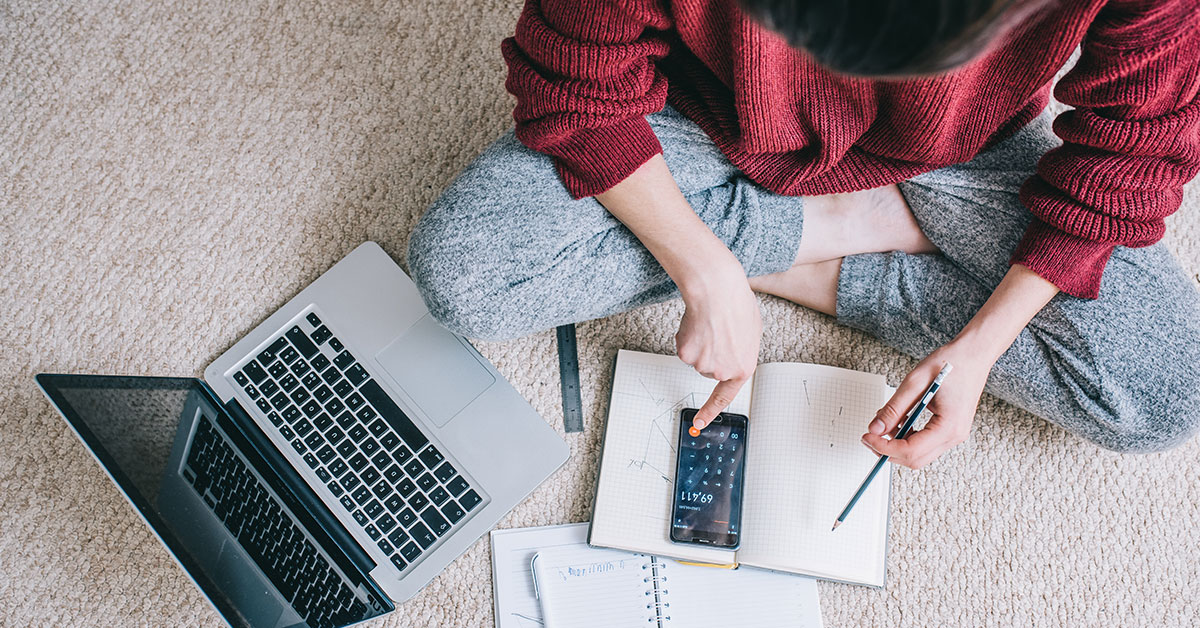 Young woman with a calculator planning her monthly budget