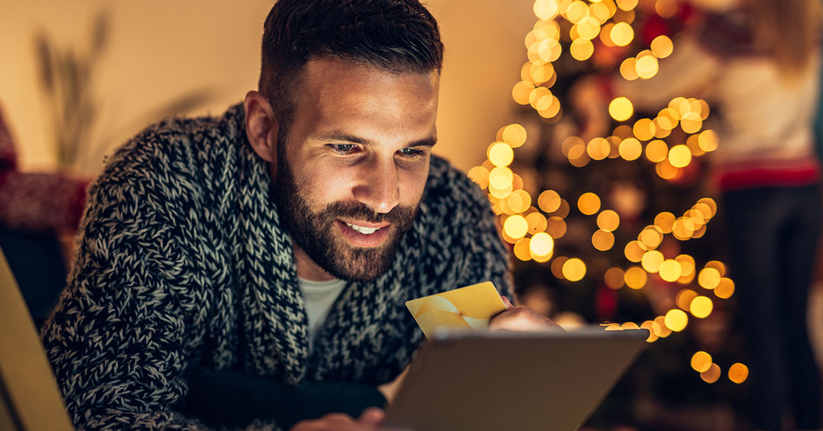 Man using an iPad to buy his holiday gifts online
