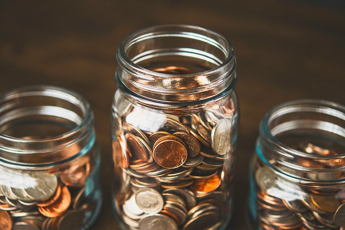 Image of jars with money, labeled travel, Education and House