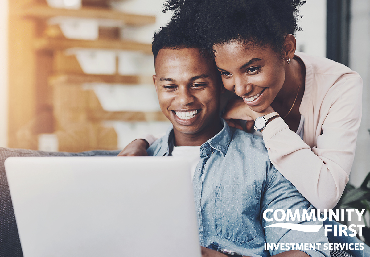 Young Couple Smiling Looking at Laptop