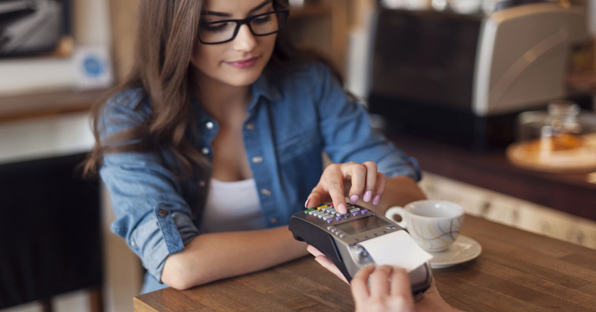 Woman using her credit card at a cafe