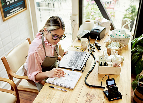 Woman Managing Finances with Laptop and Pad