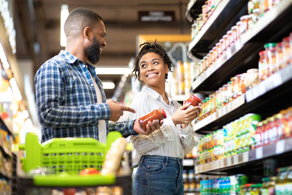 Couple in a grocery store shopping and smiling.