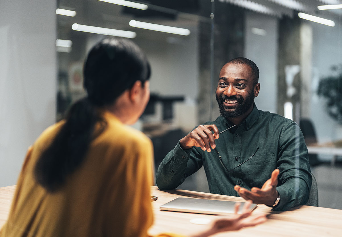 Man and Woman Talking at Desk