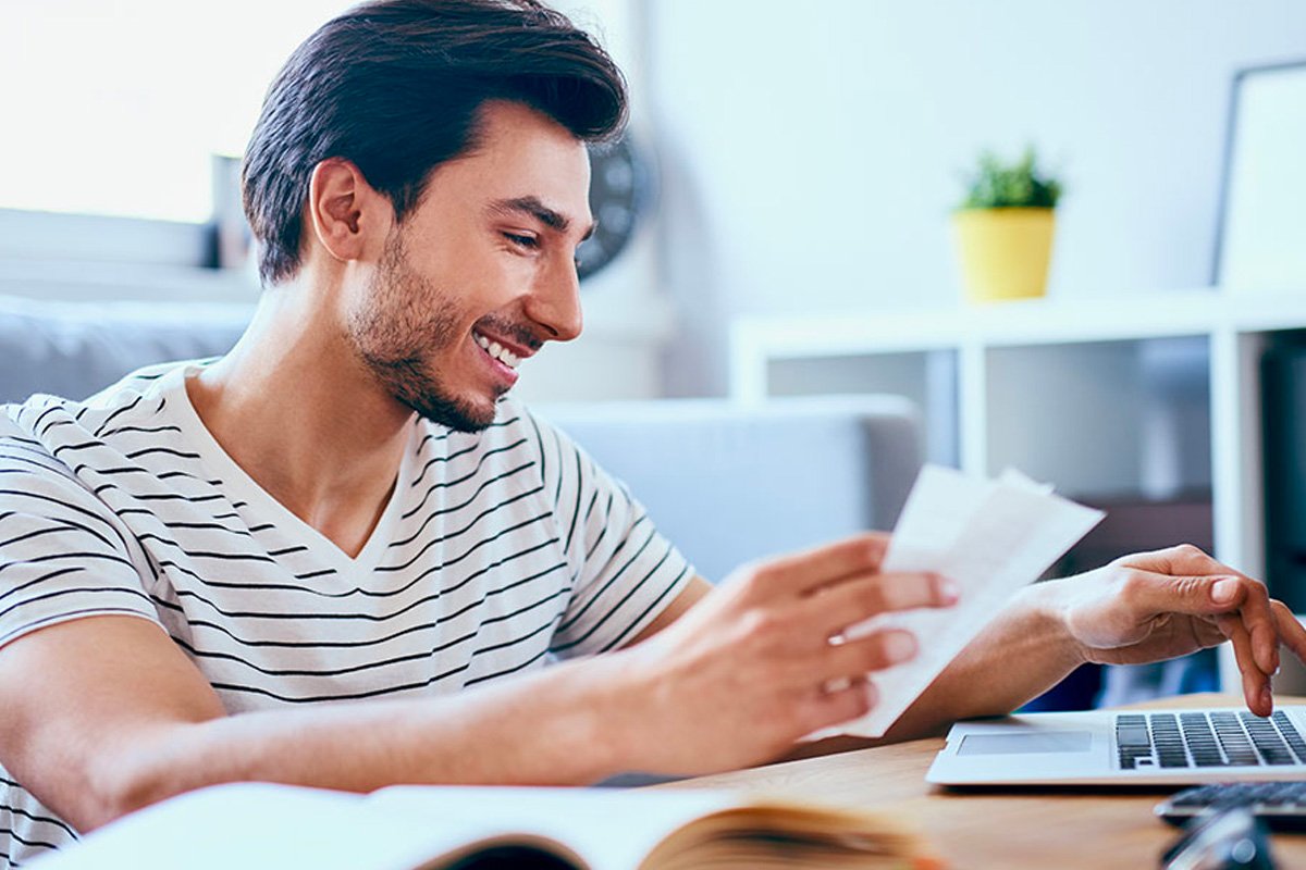 Man reviewing documents with his laptop.