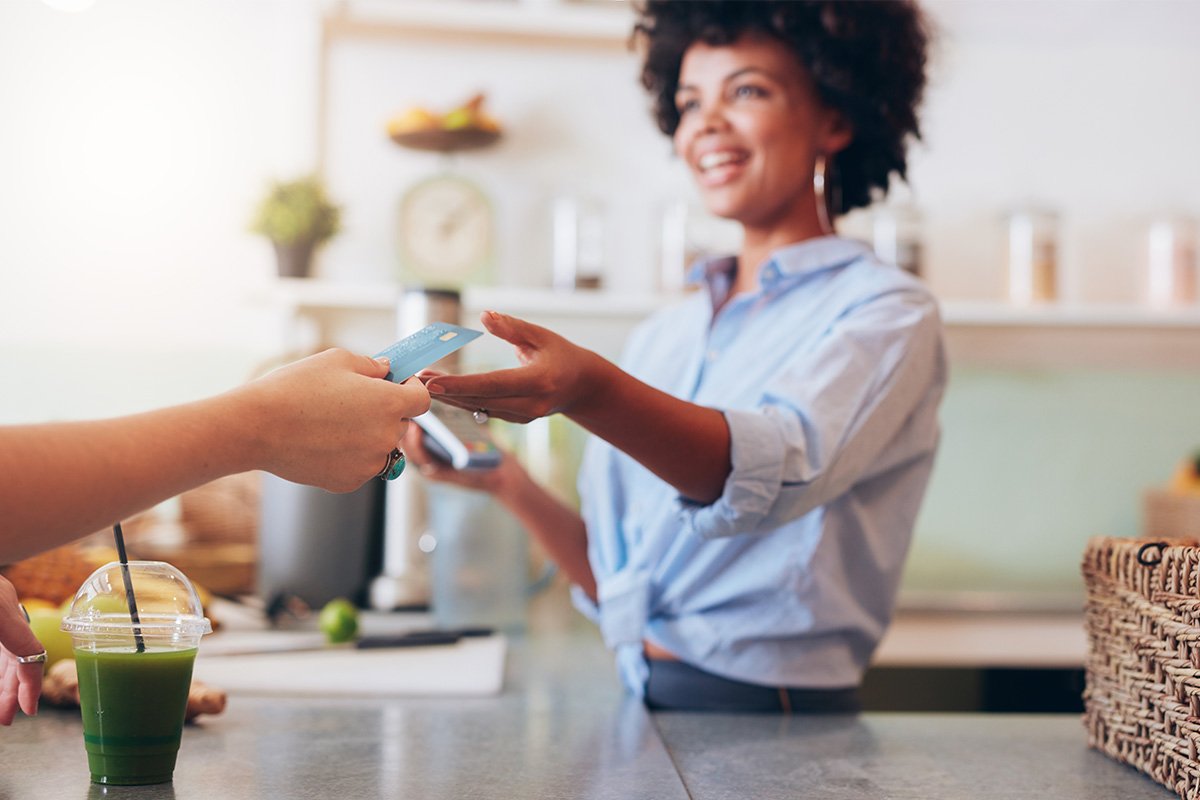 Woman receiving a card to be swiped at the point of payment