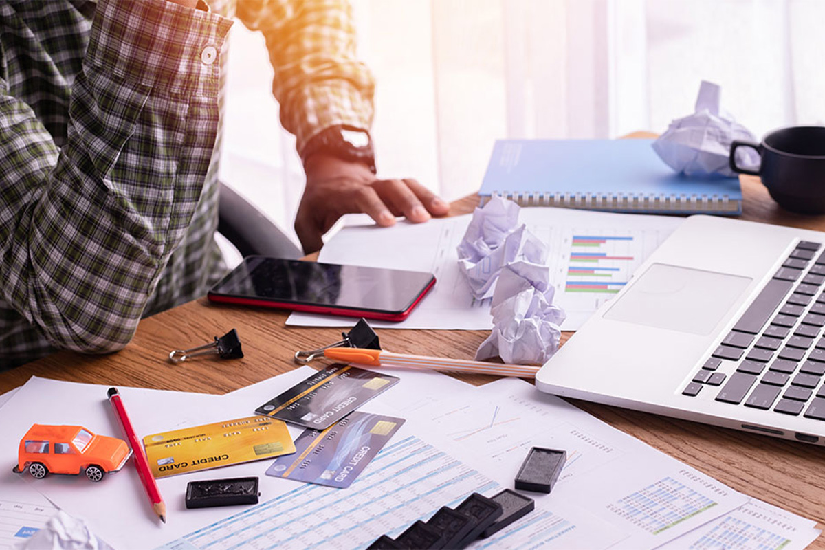 credit cards, laptop and man leaning on desk
