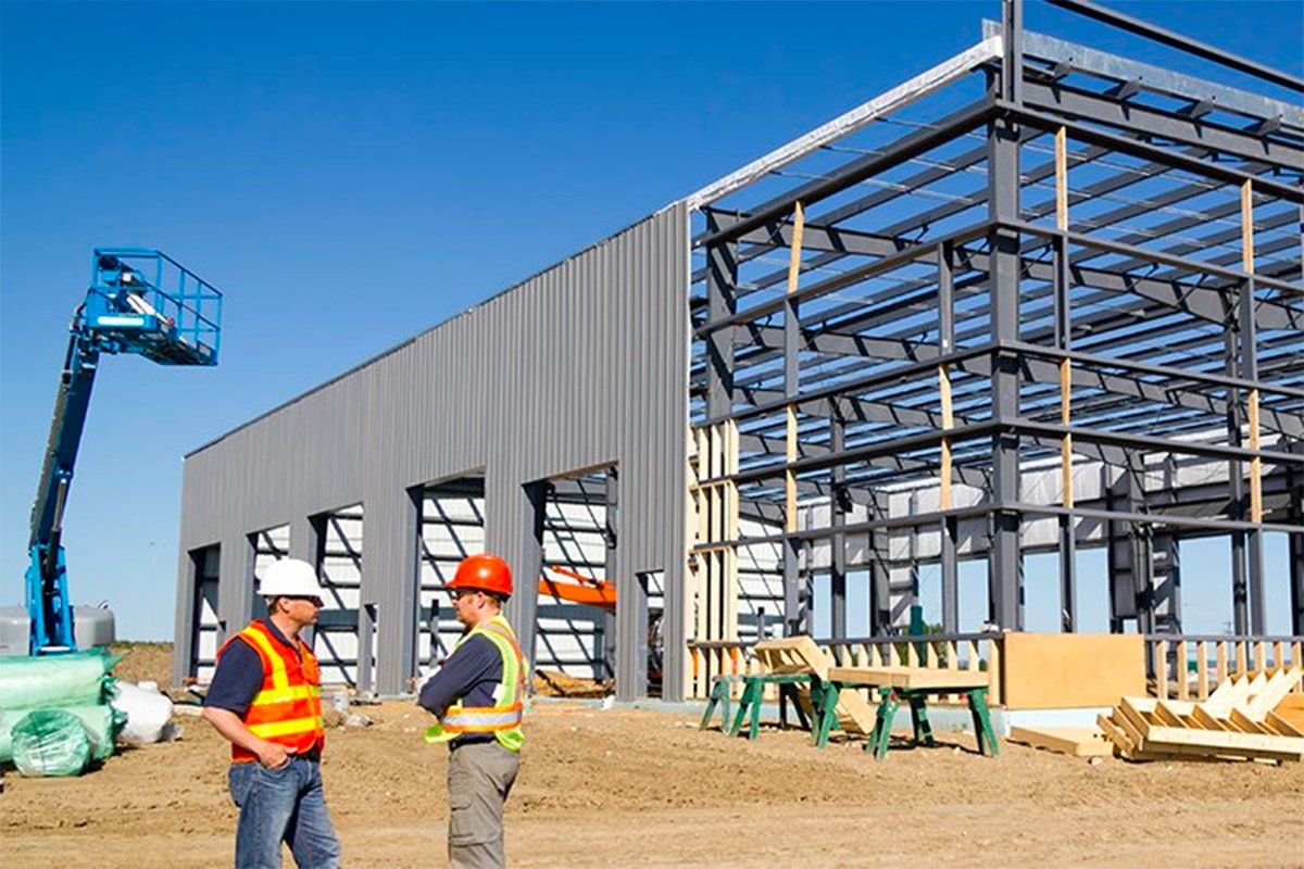 Two workers standing in front of building under construction