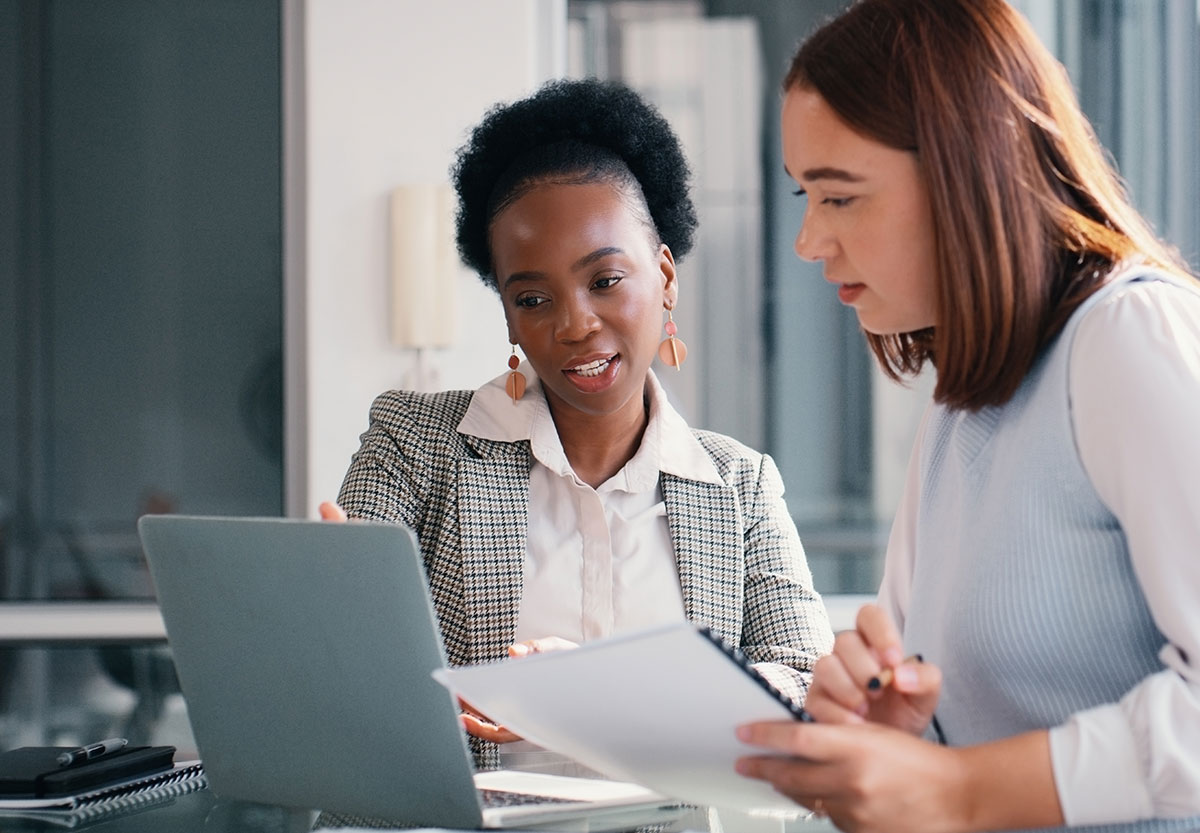 Two Women Looking at Laptop Screen Smiling