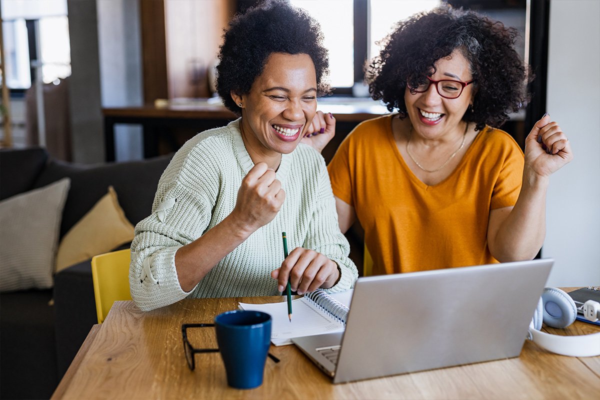 women at a table looking at a laptop