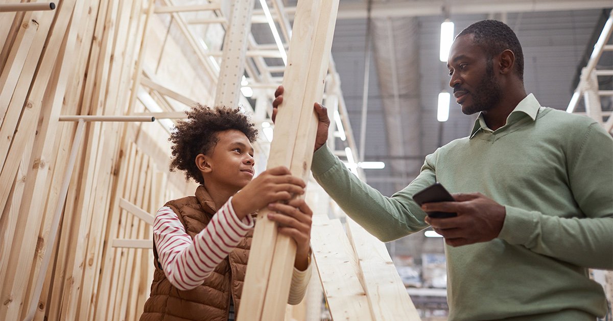 Father and son picking out lumber at a hardware store for a home improvement project