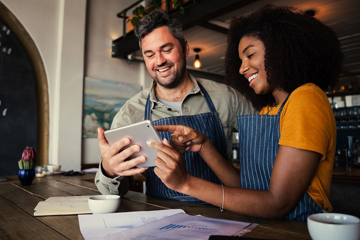 Woman showing something on a tablet to a co-worker