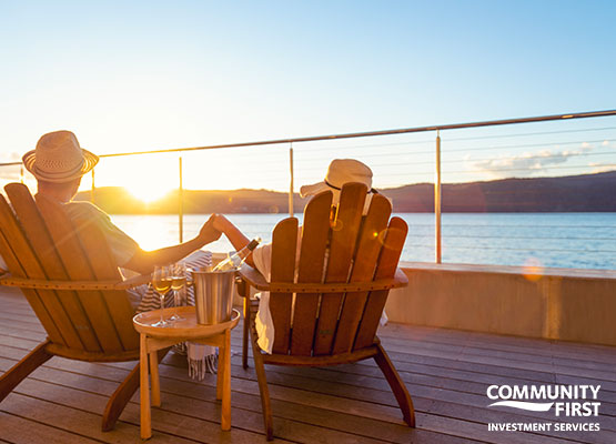 Couple overlooking water in adirondack chairs