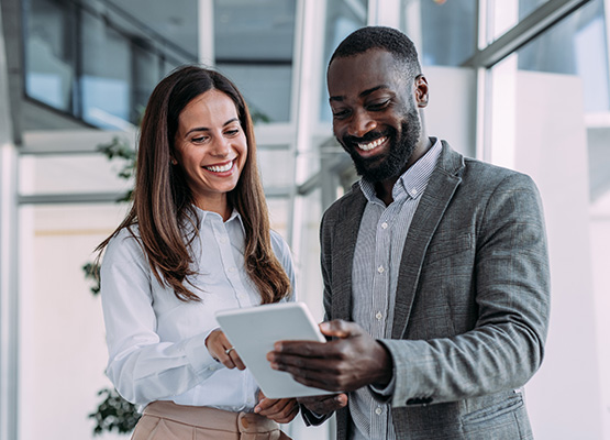 Man and Woman Smiling at Tablet