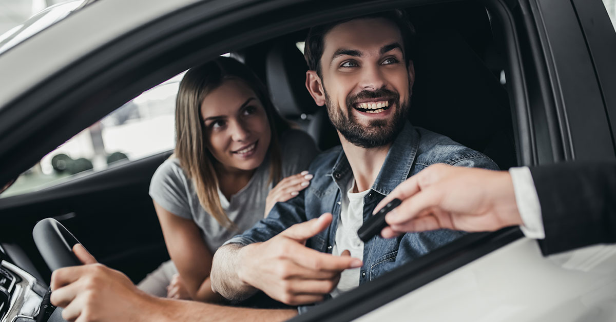 Couple in a car receiving keys