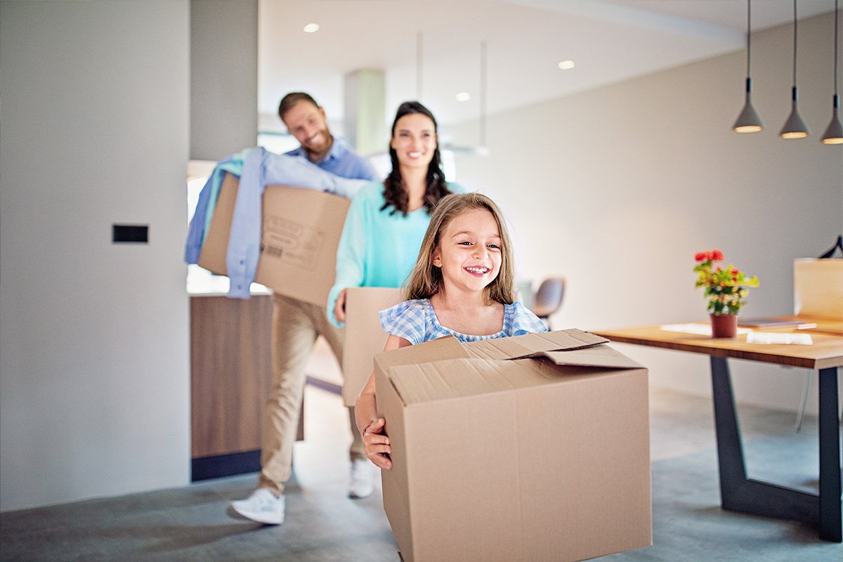 family carrying boxes into a house