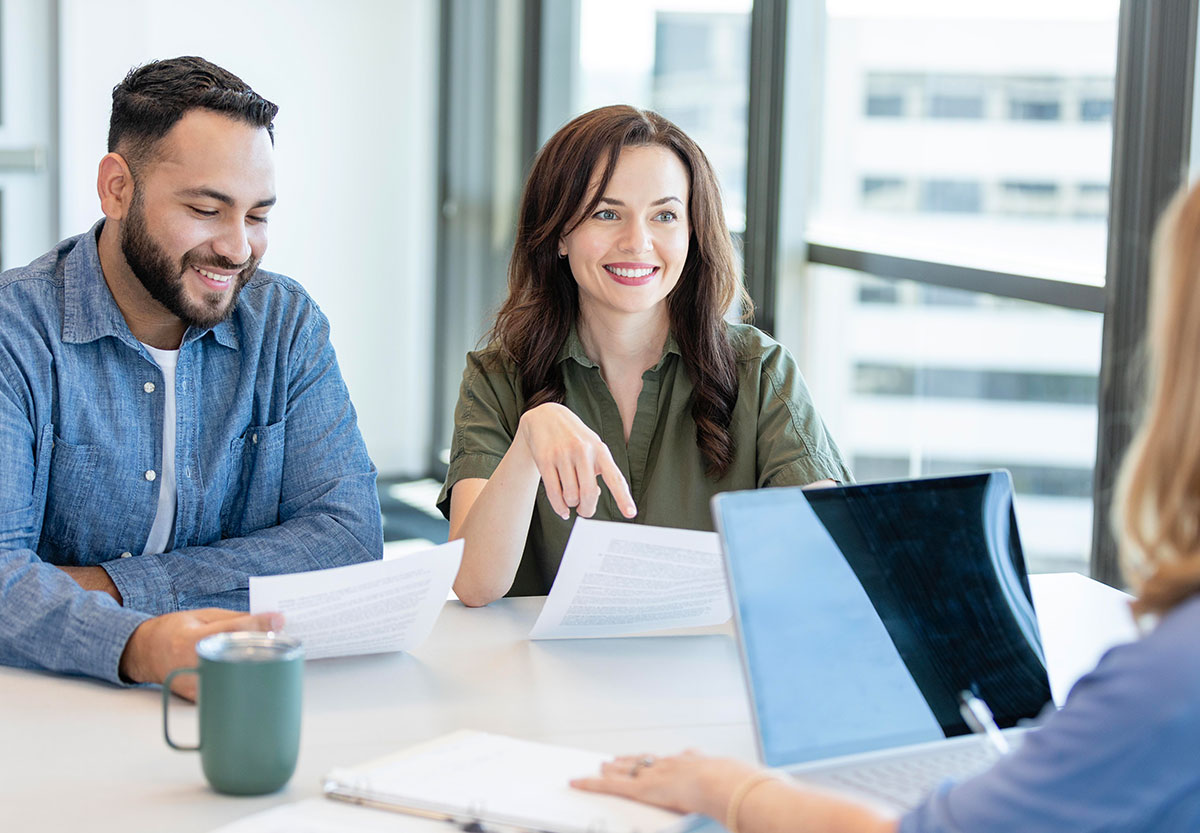 Smiling couple at desk with advisor