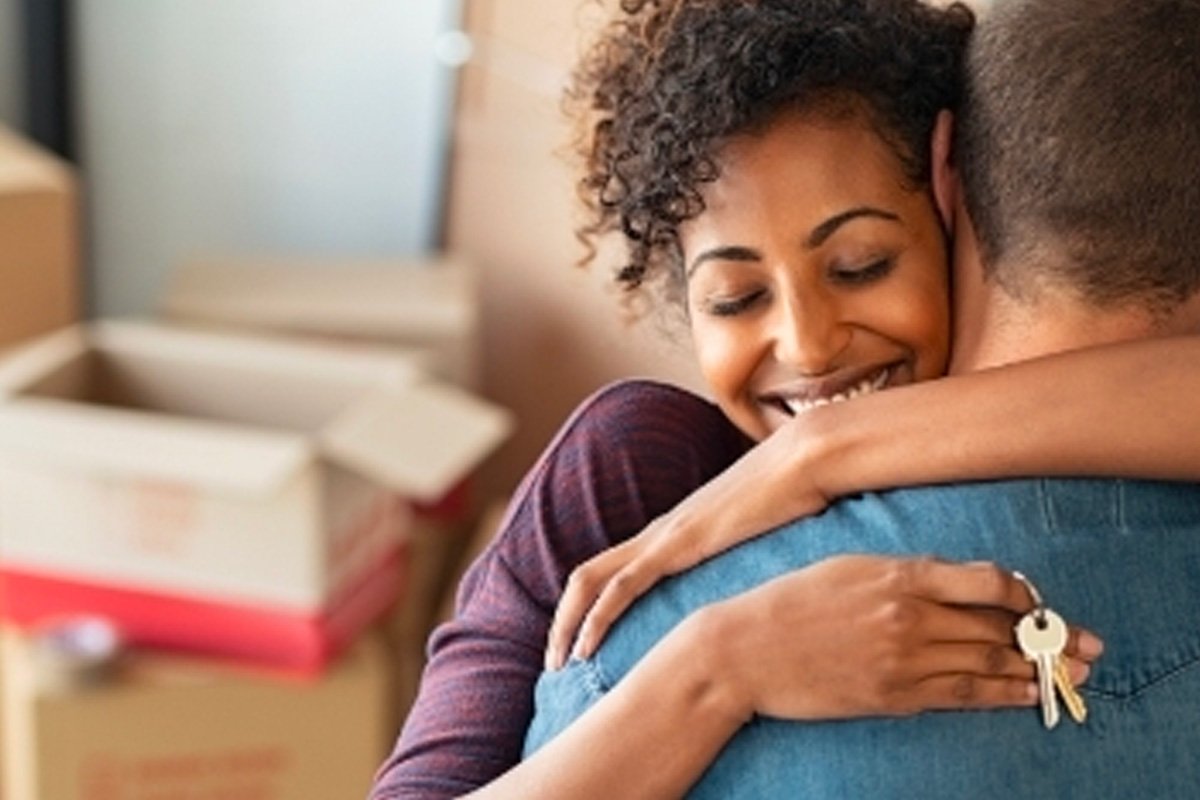 two people hugging while one holds keys