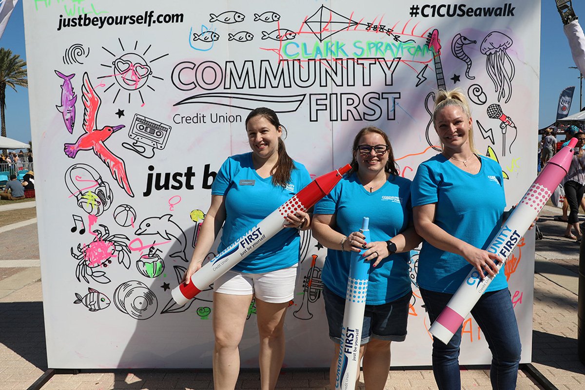 cares foundation people holding over-sized crayons in front of a display