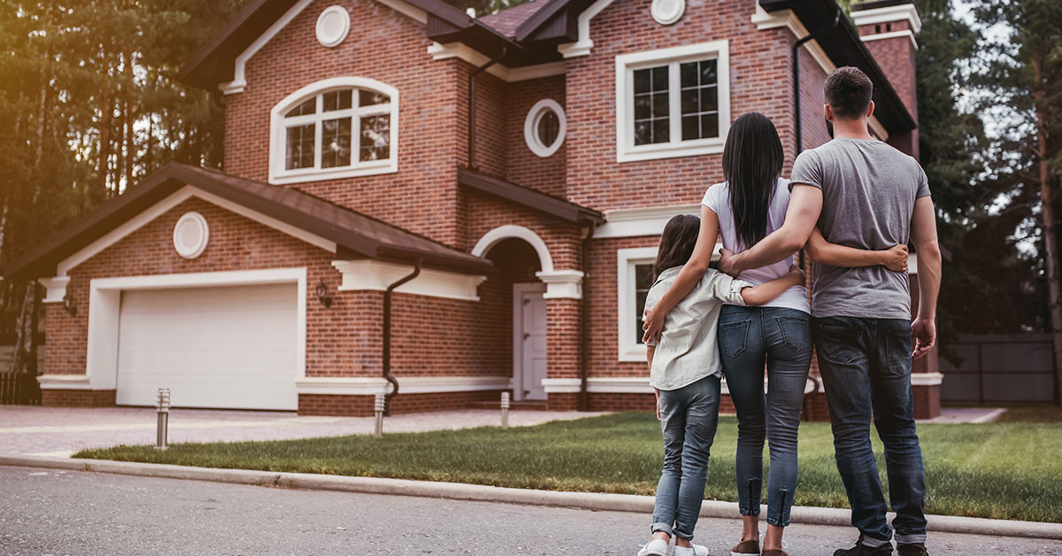 Family standing in front of their new home.