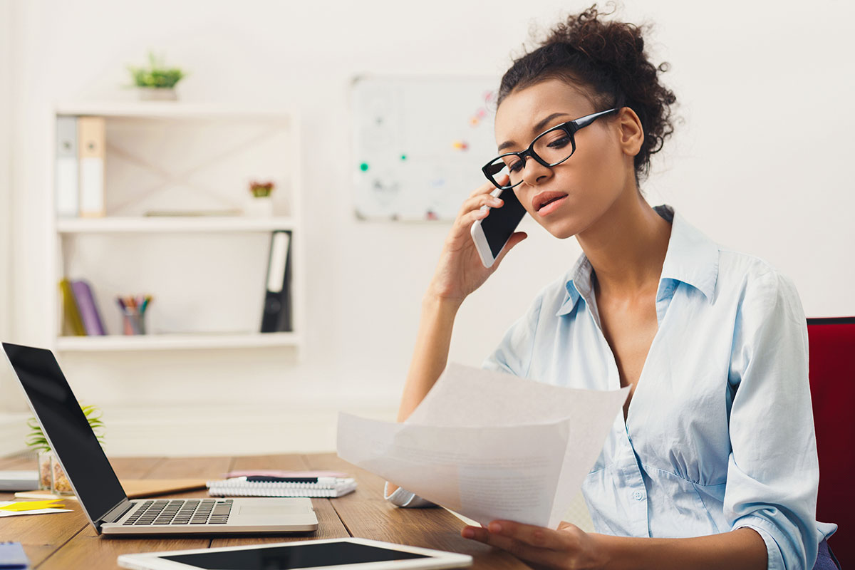 woman at her desk while on the phone