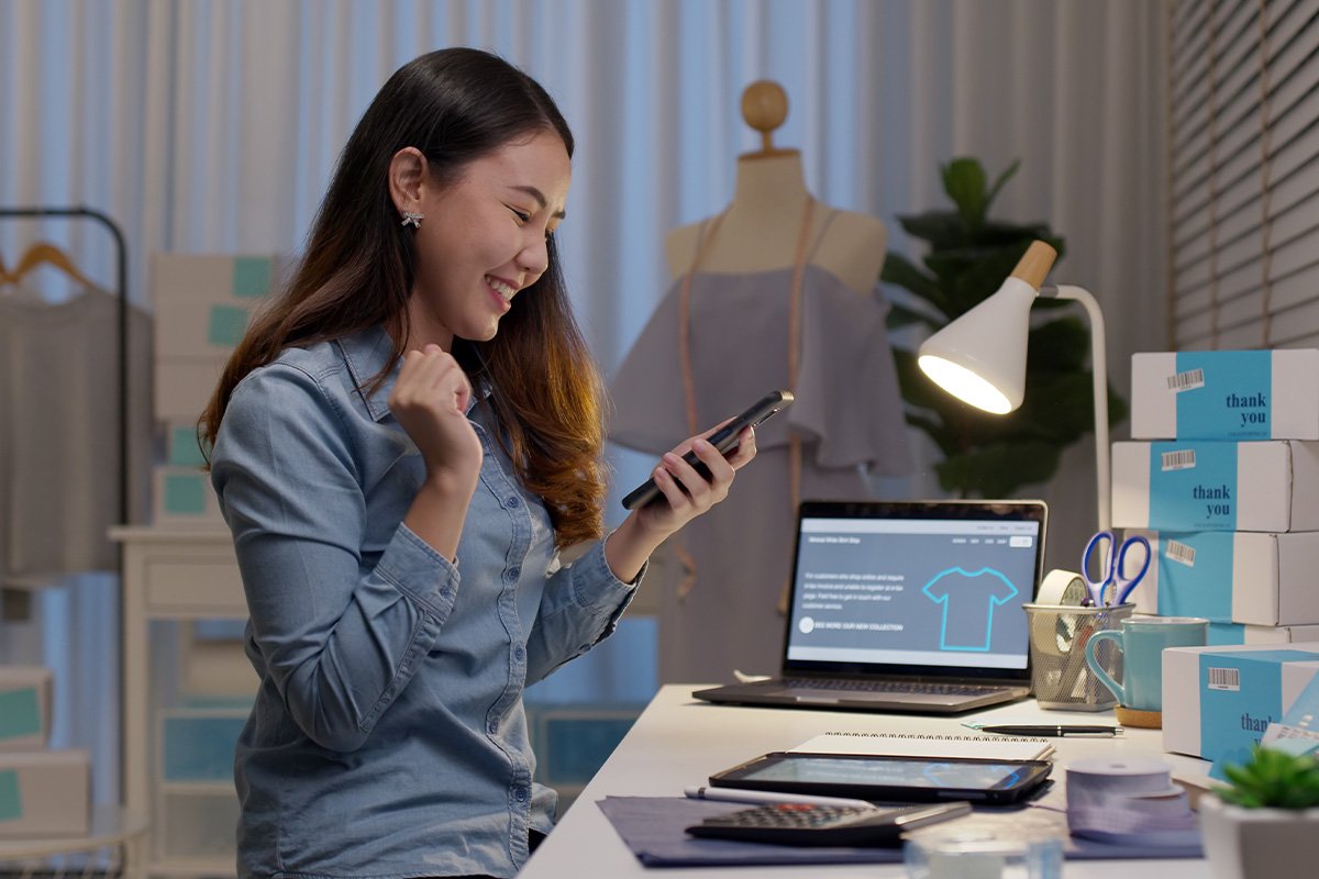 Woman sitting at her desk at work checking her phone