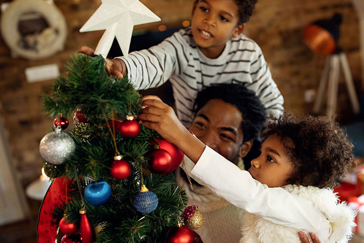 happy family puts star on christmas tree