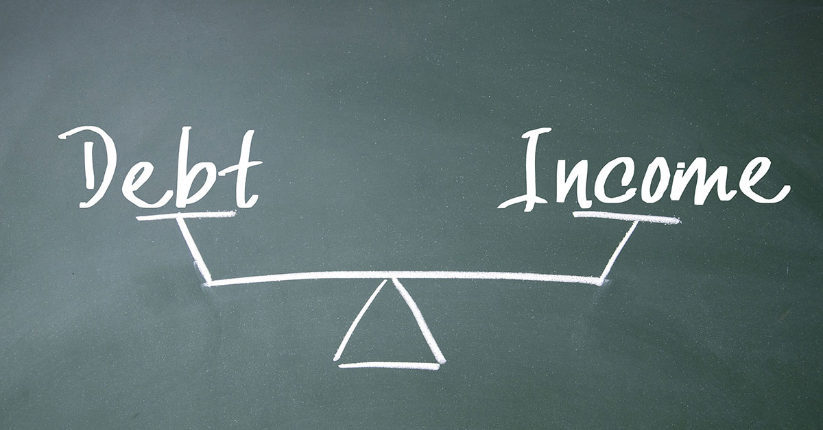 Chalk drawing of words 'debt' and 'income' on either side of a scale