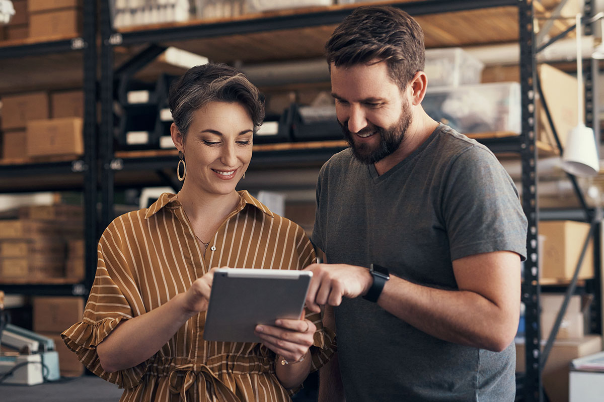Woman and Man Using Tablet in Warehouse